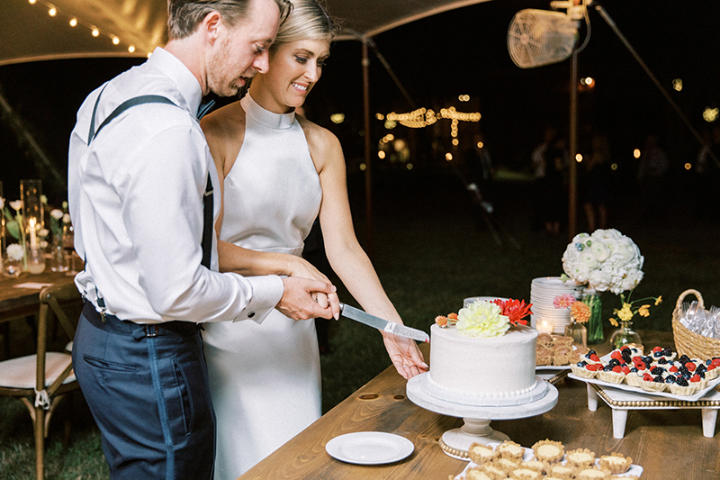 Bride and groom cutting wedding cake.